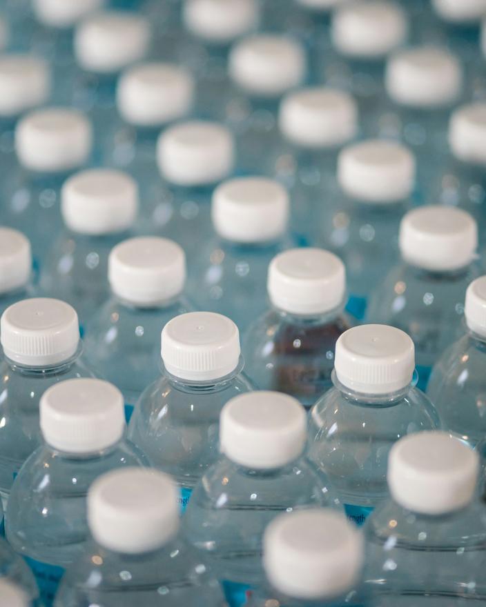 Lots of water bottles grouped together with the camera showing the top quarter of them.