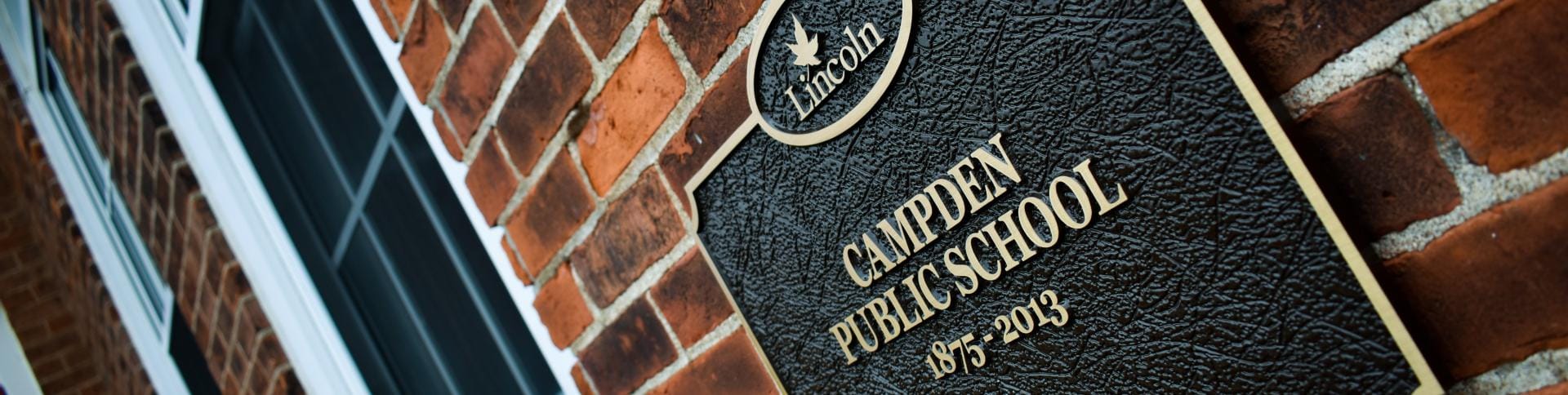Plaque on a brick wall that reads "Campden Public School"