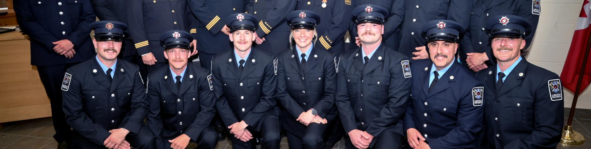 Firefighters in their uniforms posing for a photo.