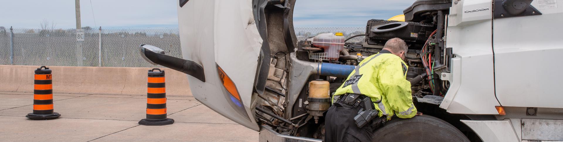 Police officer inspects a transport truck at the Vineland Inspection Station.