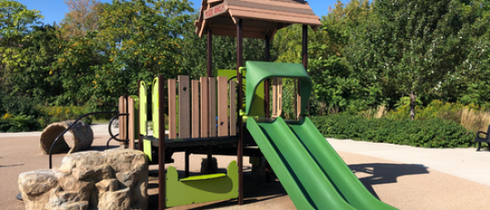 Playground equipment with slides and trees in background