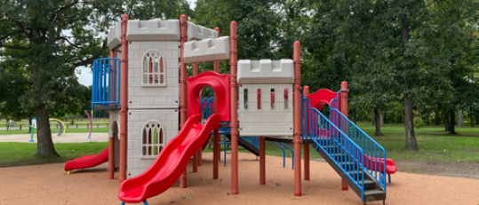 Playground equipment with slides, stairs and trees in background