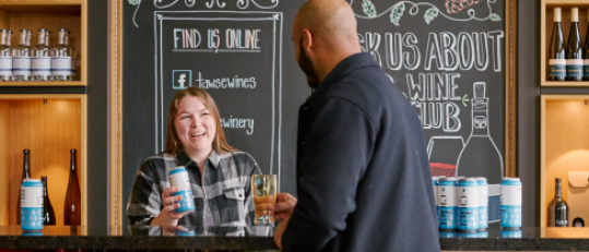Bartender serving patron at bar