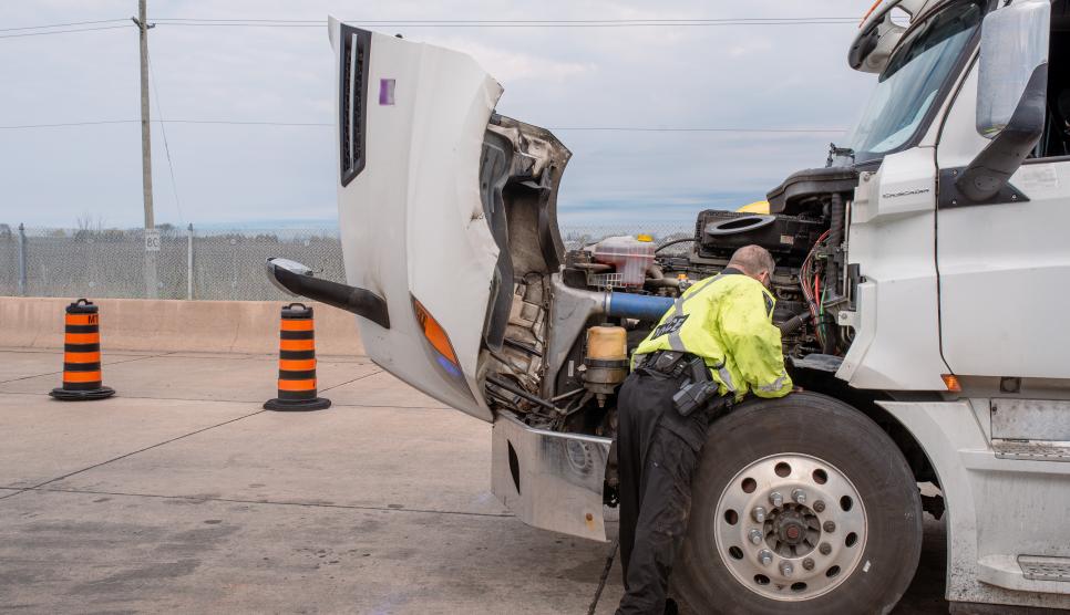 Police officer inspects a transport truck at the Vineland Inspection Station.