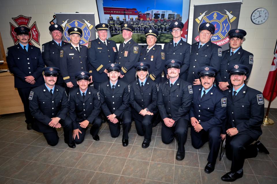 Firefighters in their uniforms posing for a photo.