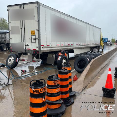 Transport truck stopped with tires being replaced.